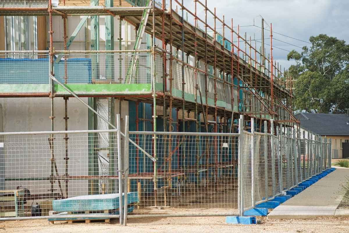 Metalna zaštitna ograda oko gradilišta sa skelama, koja sprečava neovlašćen pristup i obezbeđuje prostor tokom građevinskih radova.